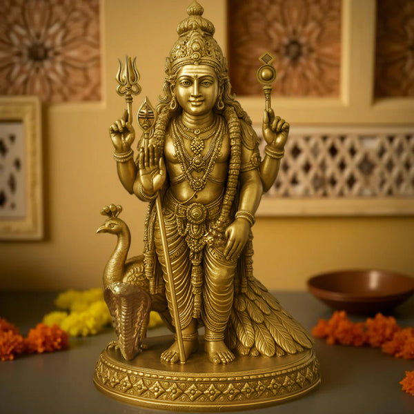 Gold-colored statue of a deity with a peacock on a table with decorative items.